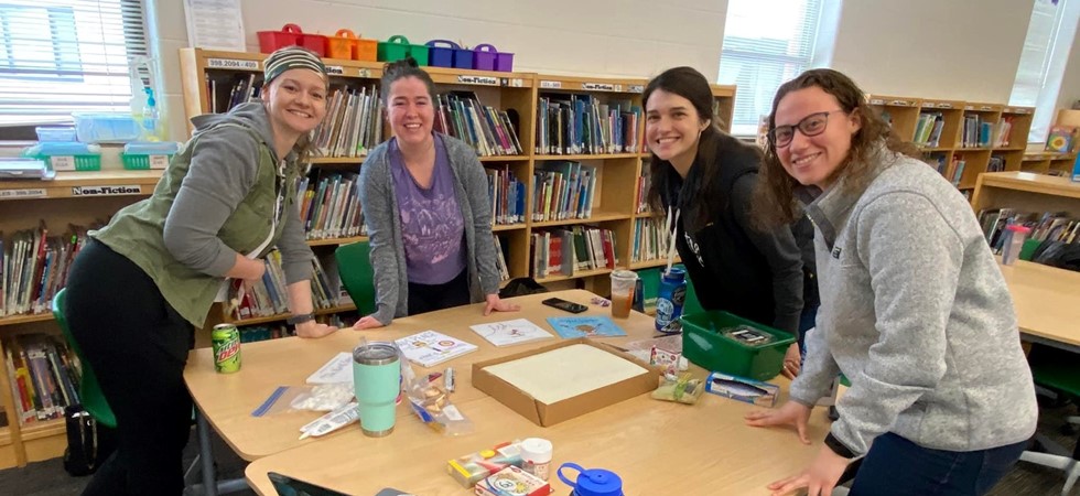 Four female teachers over table