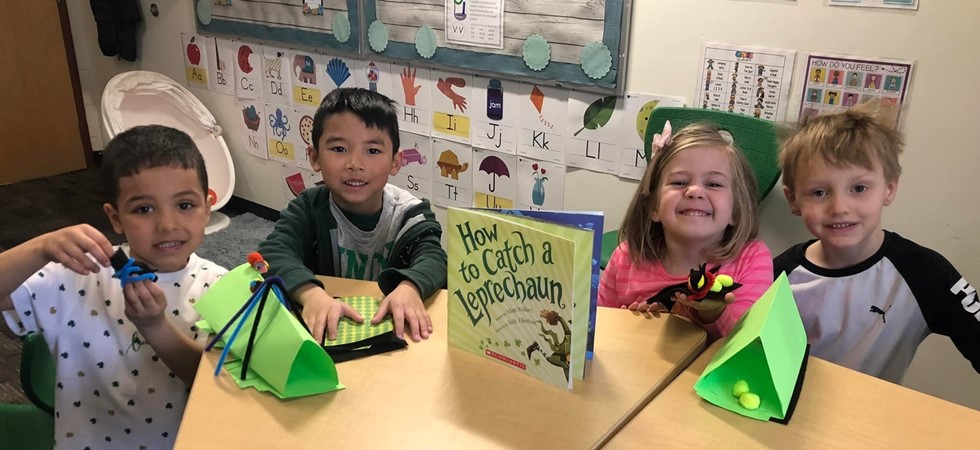 Four students smiling at table