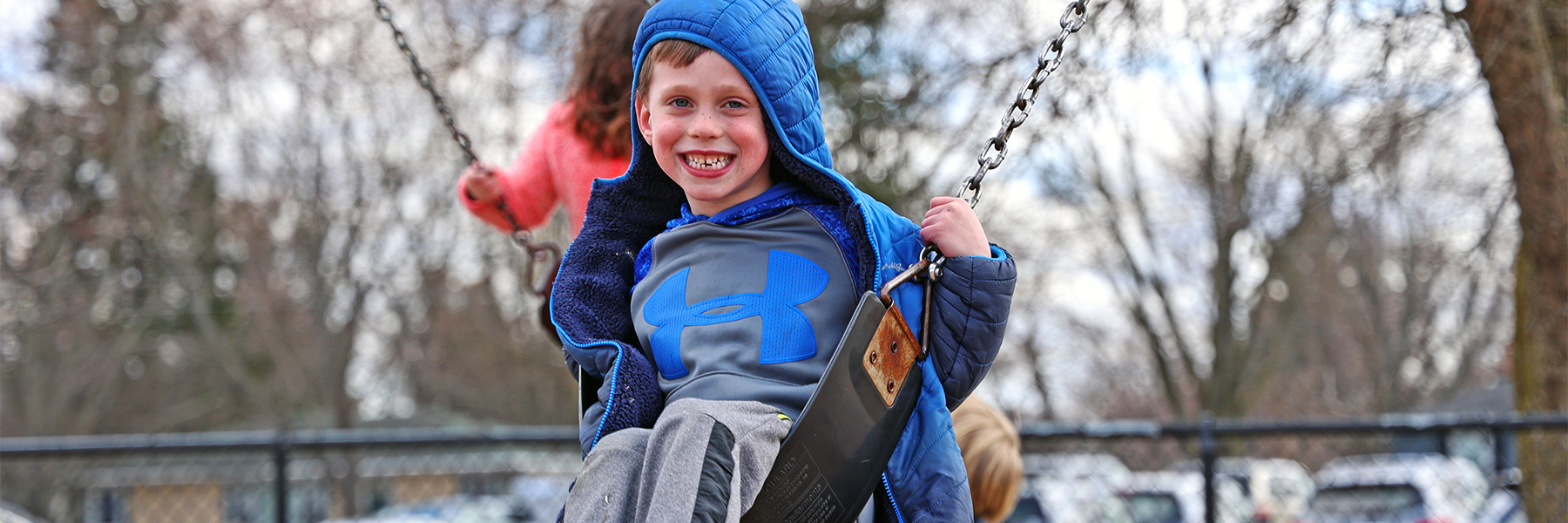 Boy swinging on swings smiling