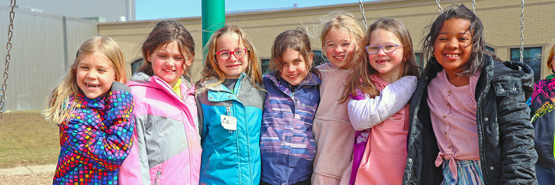 Girls smiling together in group on playground