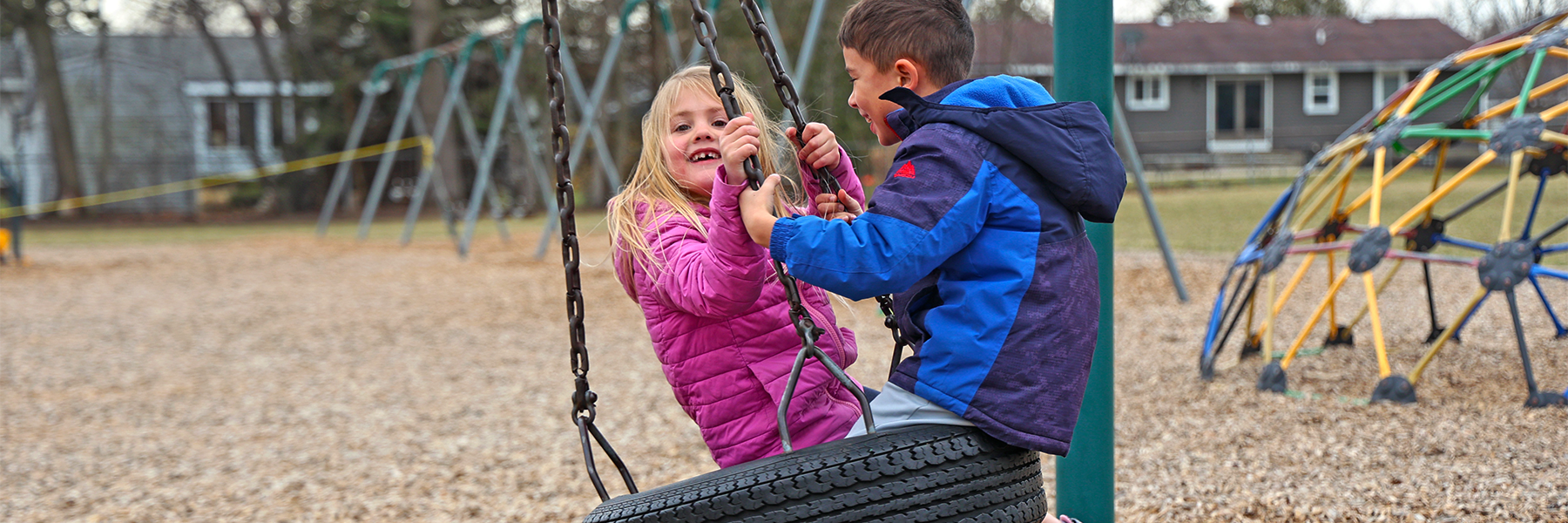 Boy and girl on tire swing