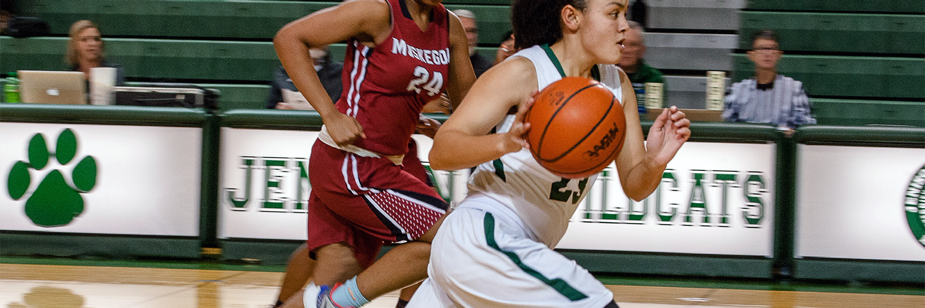 Girl with basketball running down court