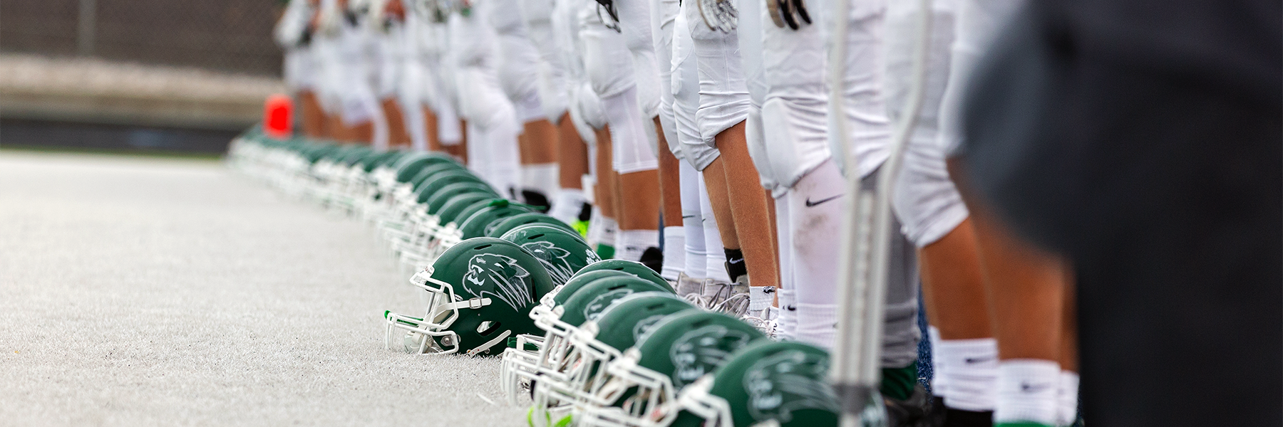 Football helmets on ground in front of players feet