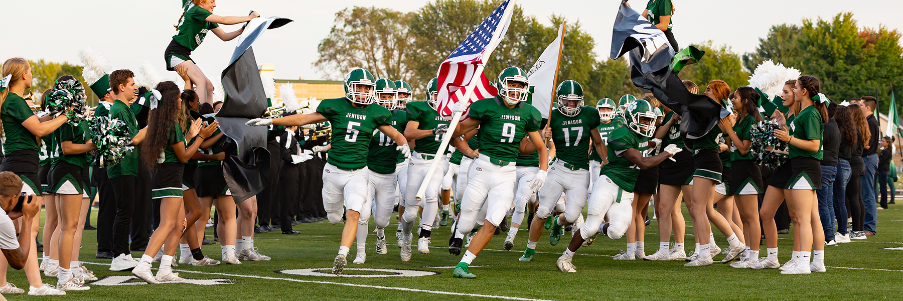 Football players running through cheerleading tunnel