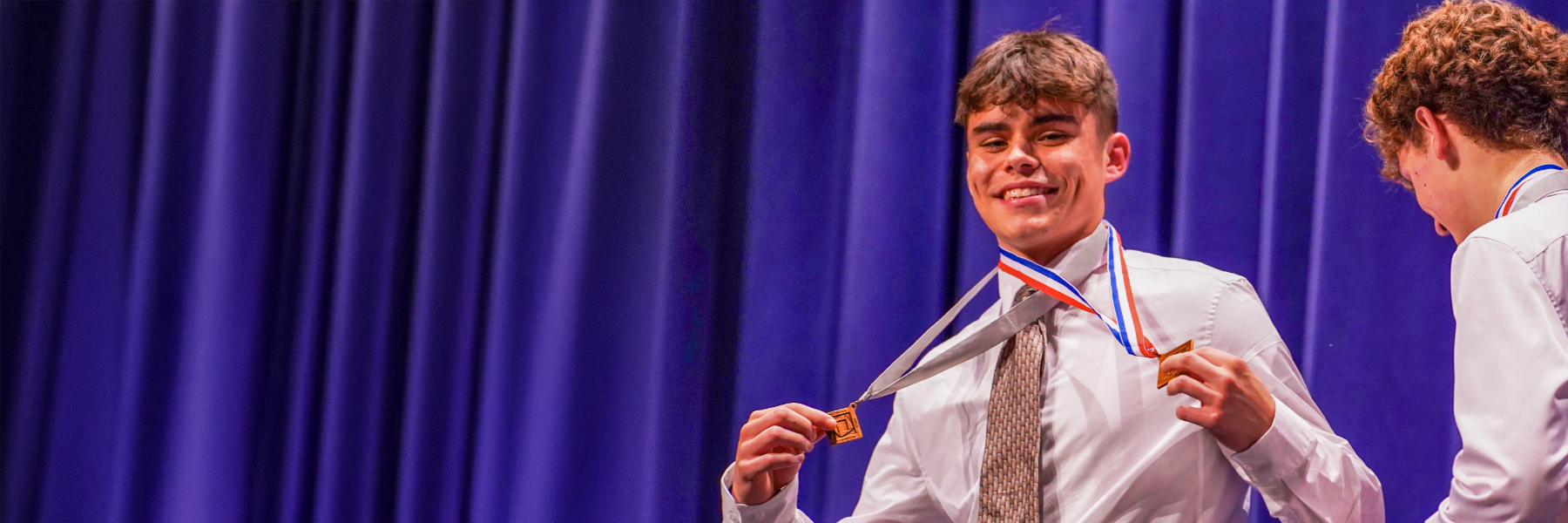 Male student holding trophies