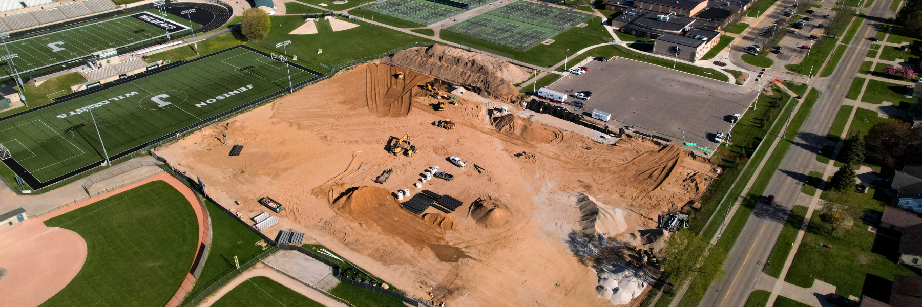 Aerial of construction, mostly dirt, where the new tennis courts will go. 