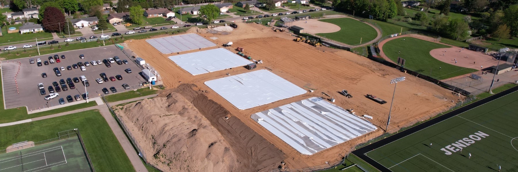 Aerial of construction, mostly dirt, where the new tennis courts will go. 